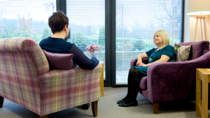 Two ladies sitting in a counselling room talking