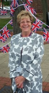 Lady smiling in front of flags