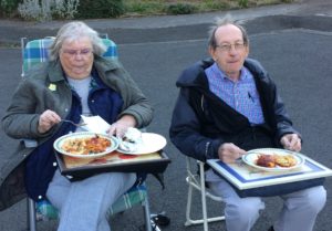 Two people sitting outside with meals