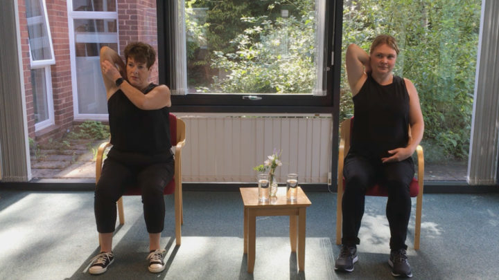Two ladies in gym kit demonstrating chair based exercises