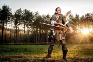 Man dressed as Robin Hood with bow and arrow