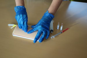 Two hands doing a syringe demonstration