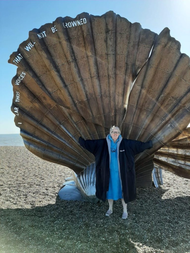 Woman in front of shell sculpture