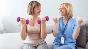 Two women doing hand weights smiling