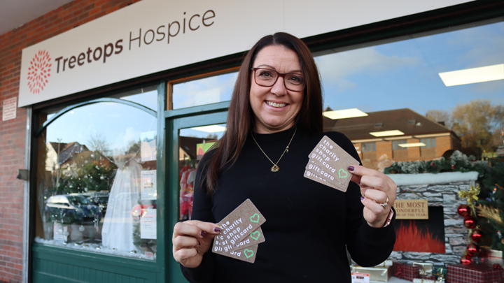 Woman smiling holding Charity Gift Cards