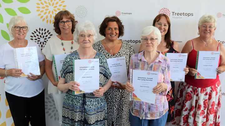 Group of women smiling holding long service awards