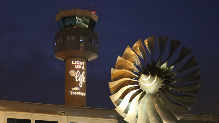 East Midlands Airport control tower lit up with Light Up a Life logo