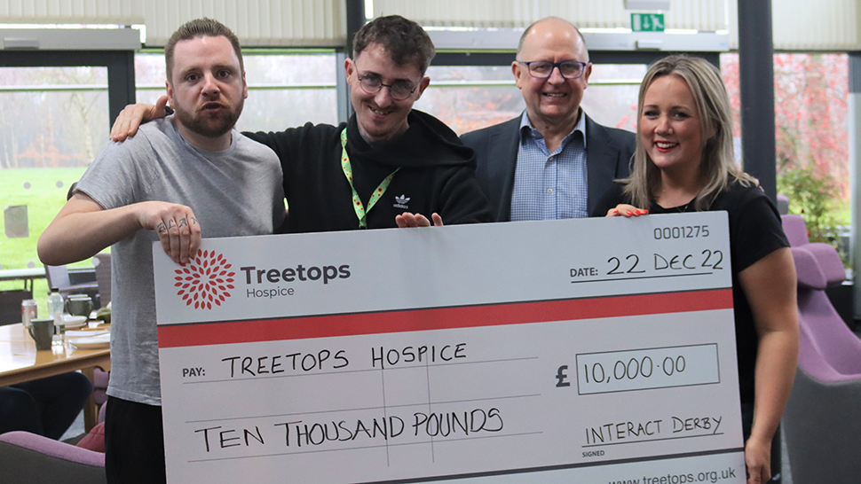 Group of people smiling with a cheque from Interact Derby