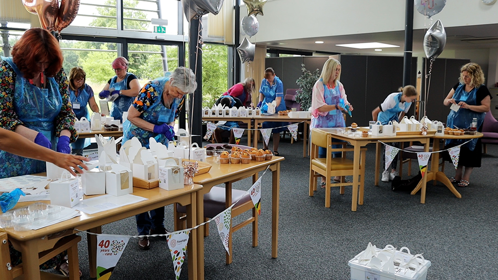 Group of people icing muffins at Treetops Hospice