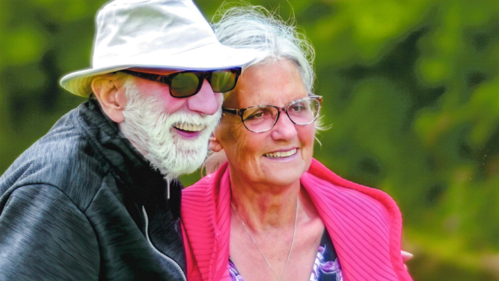 Older couple smiling with arms around each other