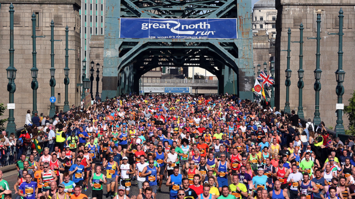 Large crowd of people running over bridge on Great North Run
