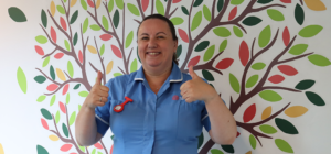 Smiling nurse wearing Treetops Hospice uniform giving thumbs up