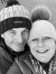 Black and white photo of couple in winter hats smiling