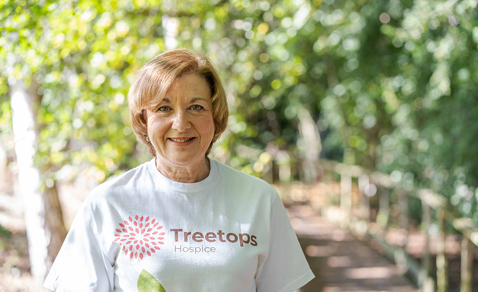 Woman smiling in Treetops t-shirt standing