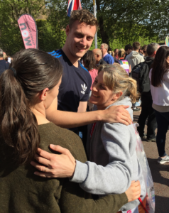Woman at the end of the London Marathon hugging son and daughter