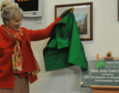 Person unveiling a plaque at the opening of a New Day Care Unit at Treetops Hospice